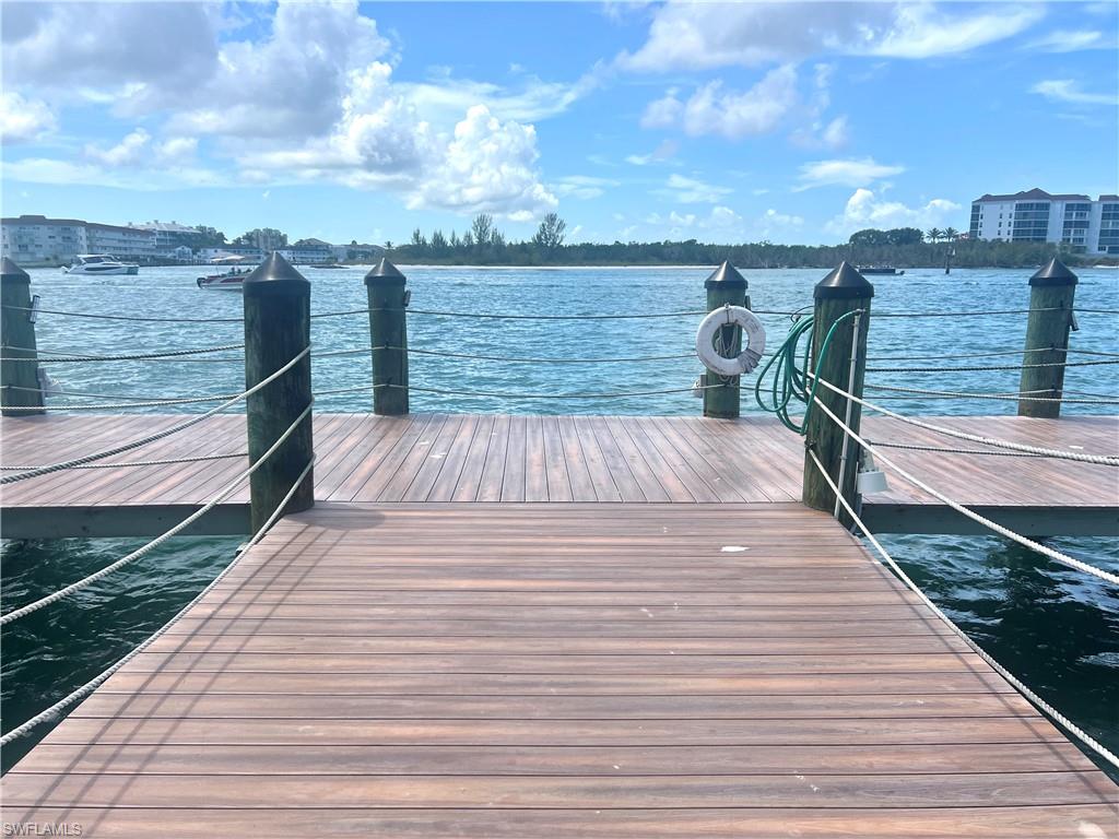Waterfront dock featuring wood-finish decking and dark pilings