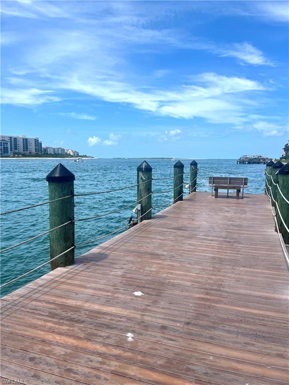 Hardwood pier extending over tranquil waters, featuring sturdy wooden pilings and a rope railing