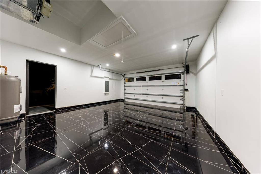Garage featuring recessed lighting and electric panel