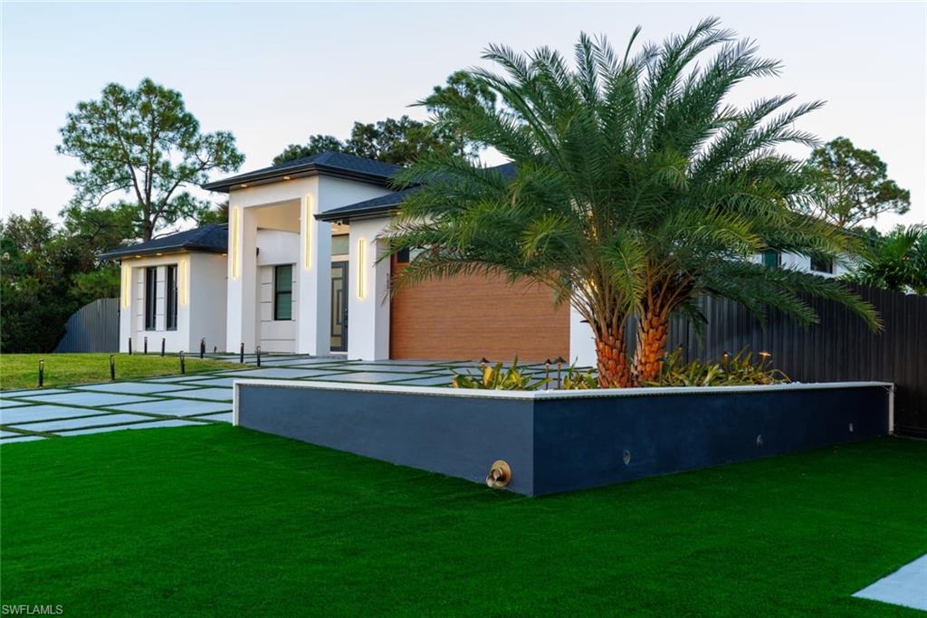 Beautiful palm tree graces the front of the property, creating a welcoming tropical entrance.