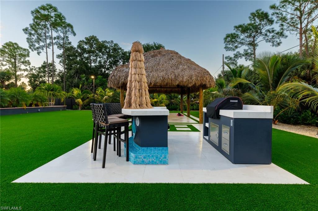 View of home's community featuring a yard, a gazebo, a patio area, and an outdoor kitchen