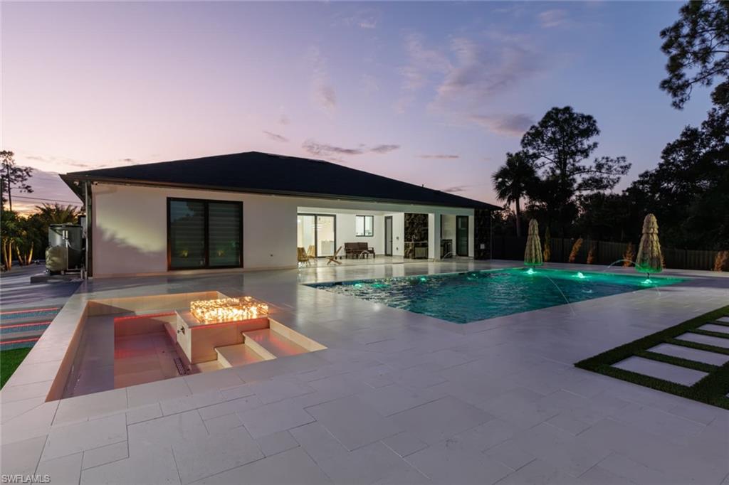 View of swimming pool with a fire pit and a patio area