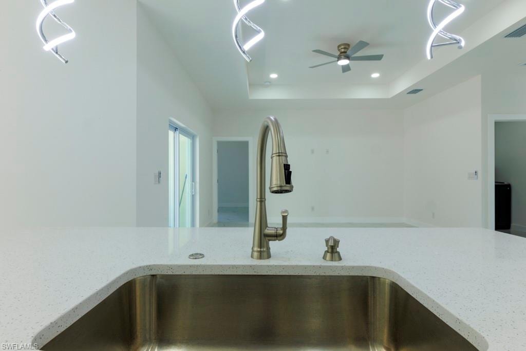 Stainless steel undermount sink with a brushed nickel gooseneck faucet set into a light-toned countertop