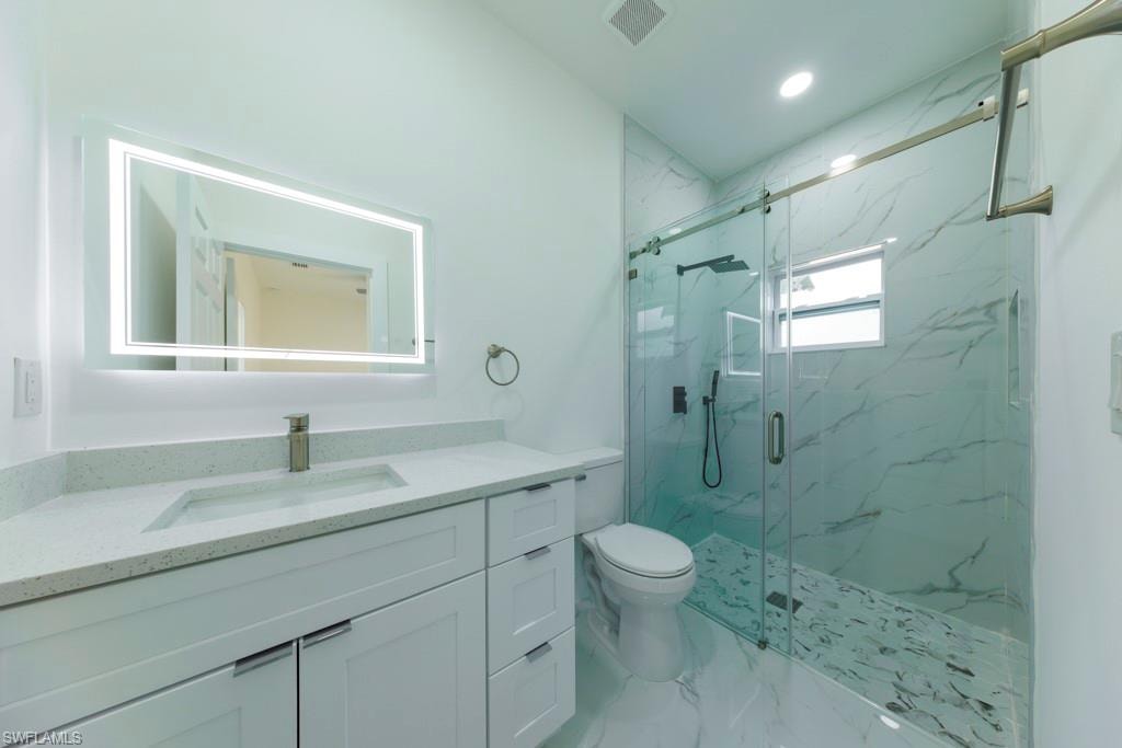 Contemporary bathroom featuring a spacious glass-enclosed shower with a sliding barn door and large format tile