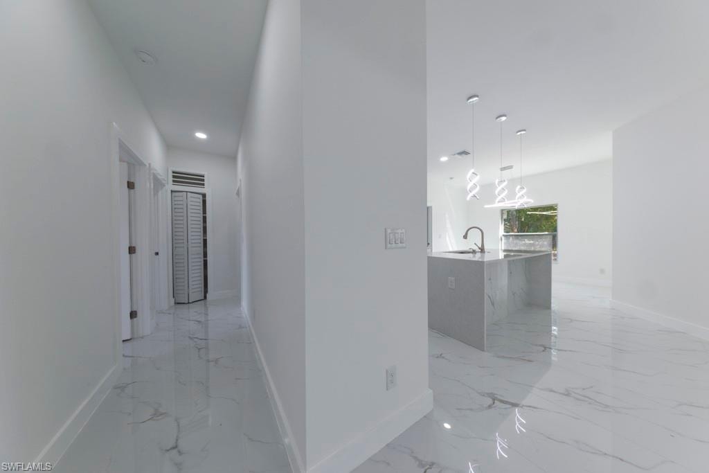 Gleaming porcelain tile flooring extending throughout, complemented by crisp white walls and recessed lighting