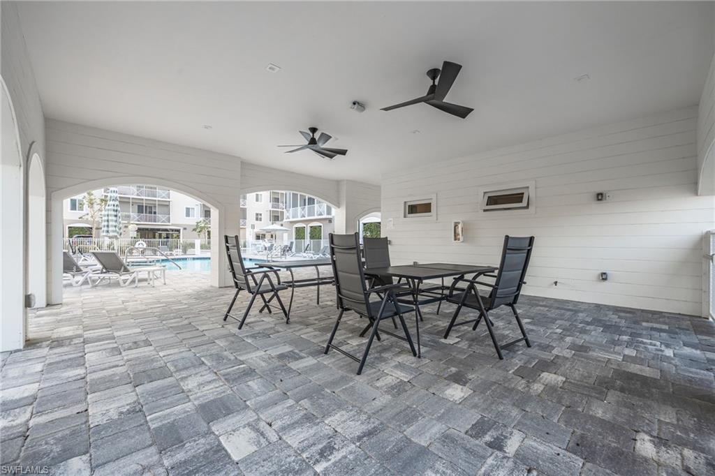 View of patio / terrace with outdoor dining area, a ceiling fan, and a community pool
