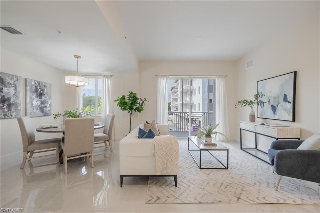 Living area with baseboards, visible vents, and light tile patterned floors