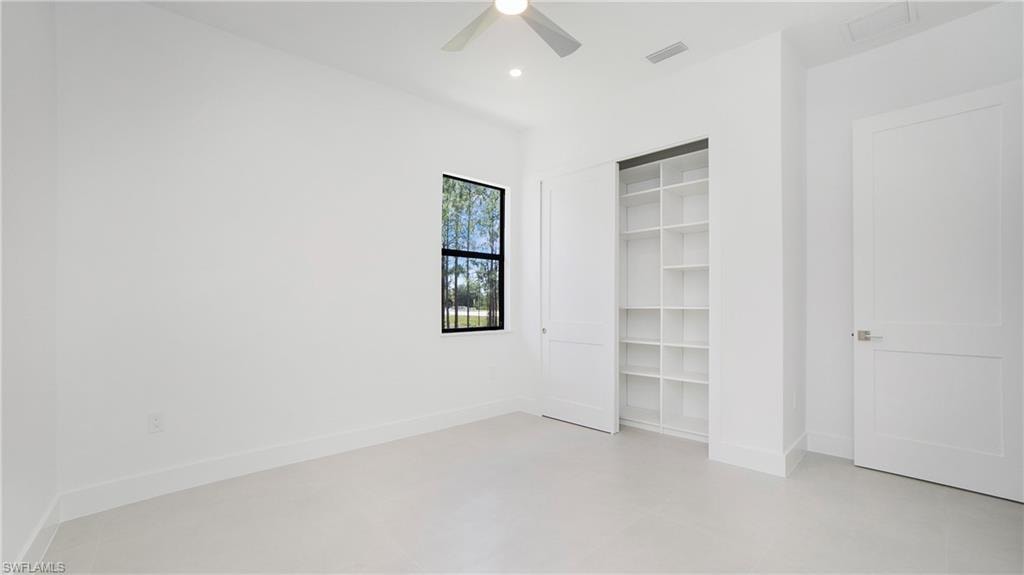 Bright interior space featuring a window with black trim, recessed lighting, and a ceiling fan