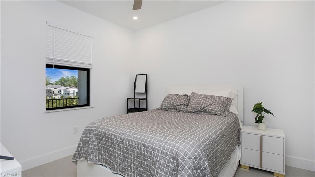 Bright room featuring a single window with blinds and dark framing