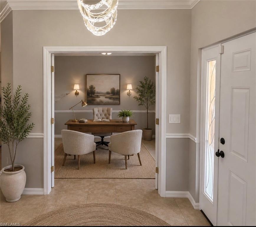 Front entry featuring tile flooring, crown molding, and a decorative chandelier