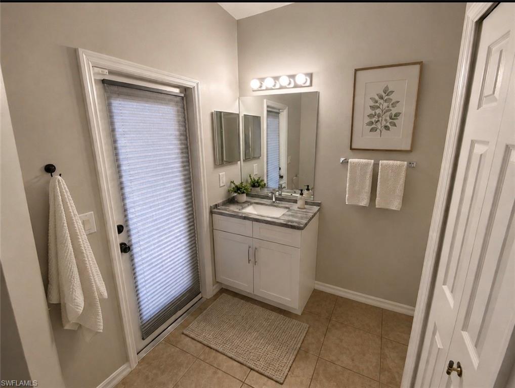 This full  bathroom featuring  white shaker cabinetry with a quartz counter top  with a rectangular undermount . It has a shower /bath tub   Linen closet with the commode tucked away for some privacy. The door goes out directlyy to the enclosed screen lanai .