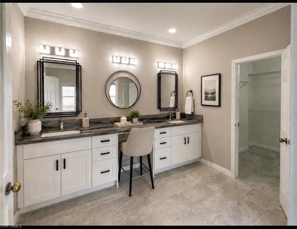 Dual vanity featuring undermount sinks, dark stone countertops, and ample storage cabinetry