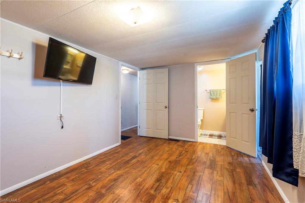 Primary bedroom with wood-style flooring and ensuite bathroom