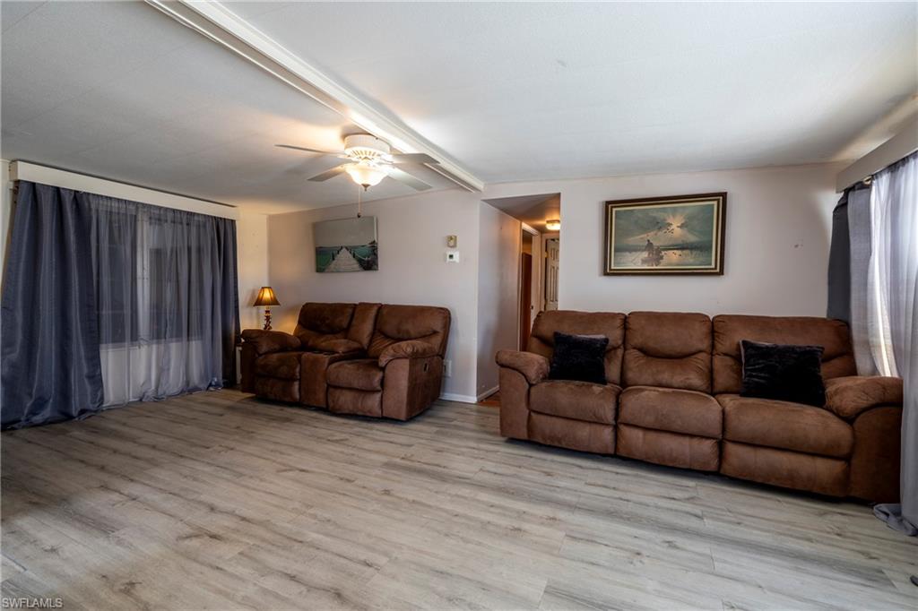 Living area featuring wood-style vinyl floors and ceiling fan