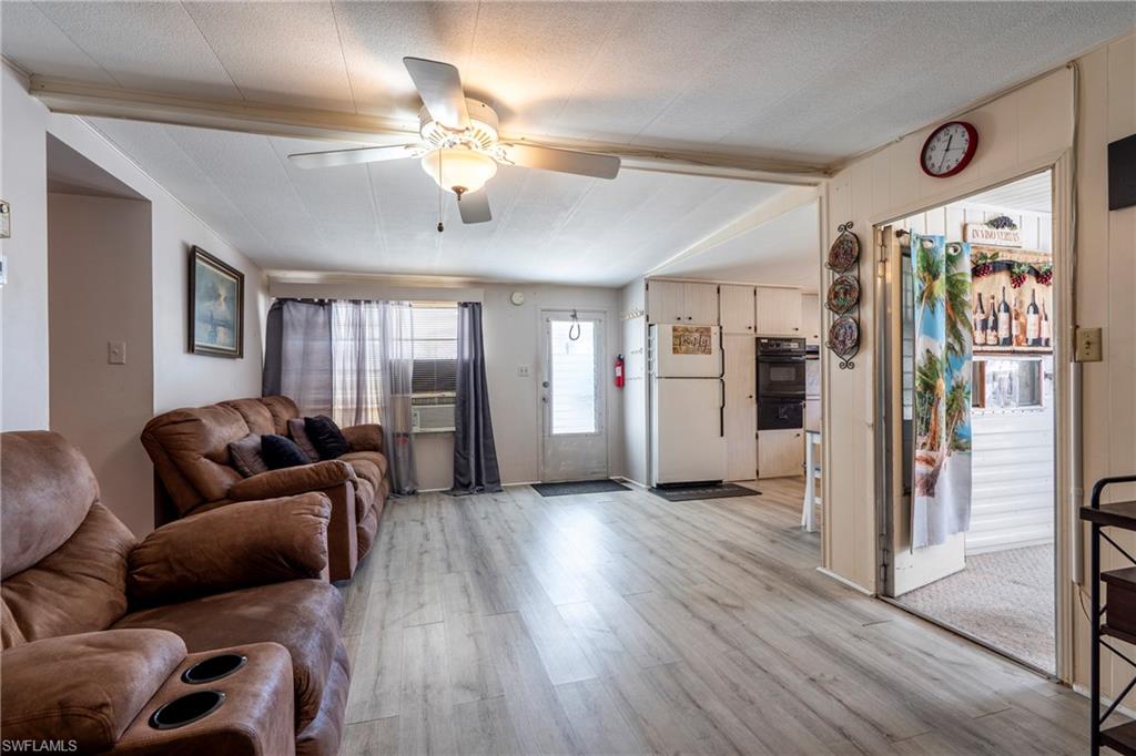 Living area with light wood-style vinyl floors and ceiling fan