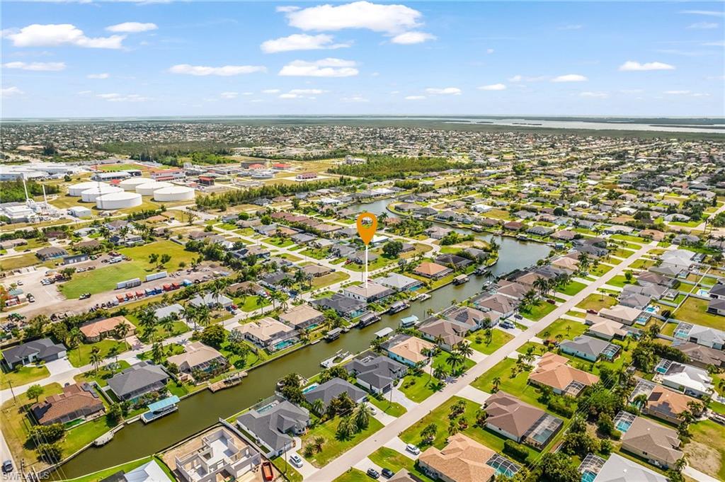 Aerial perspective showcasing a residential area with canal access, featuring single-story homes, established landscaping, and proximity to larger waterways