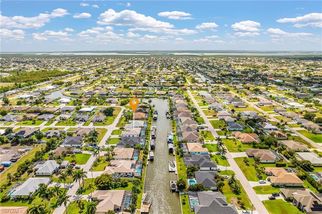 Aerial perspective showcasing a canal-front property within a residential community