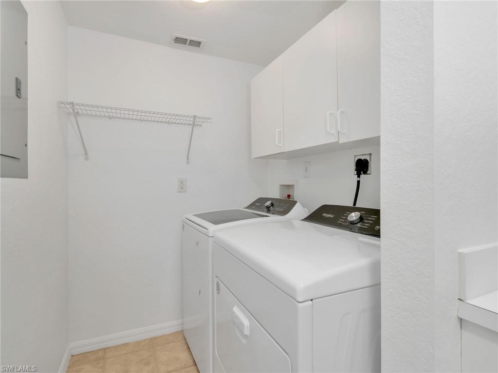 Laundry Room with Whirlpool Washer & Dryer (2025), Wire Hanging Rack, & White Cabinetry
