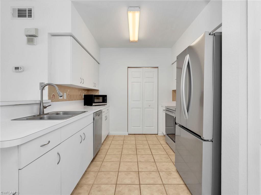 Kitchen with Tile Flooring, White Cabinetry, Stainless Steel Appliances Including new LG French Door Refrigerator & Range, Newer Whirlpool Dishwasher, Tile Backsplash & Pantry
