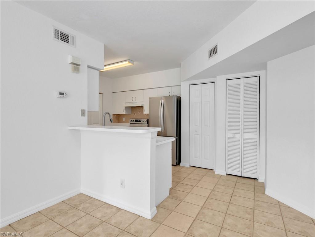 Kitchen with Tile Flooring, White Cabinetry, Stainless Steel Appliances, Tile Backsplash & Pantry