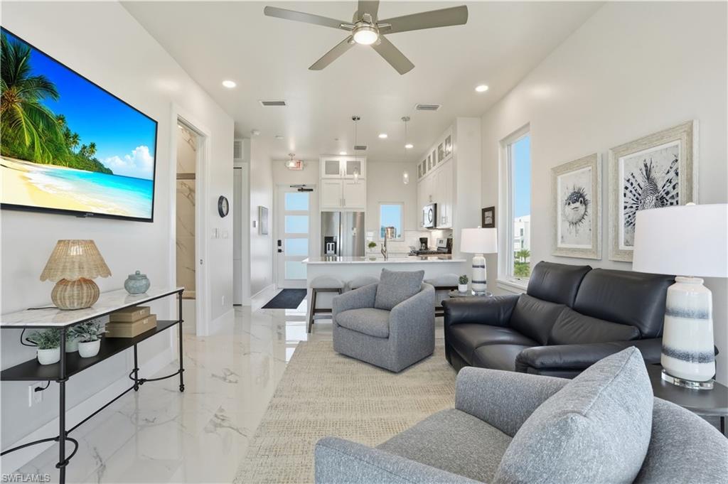 Living room with recessed lighting, ceiling fan, and light marble finish flooring - Virtually Edited Image