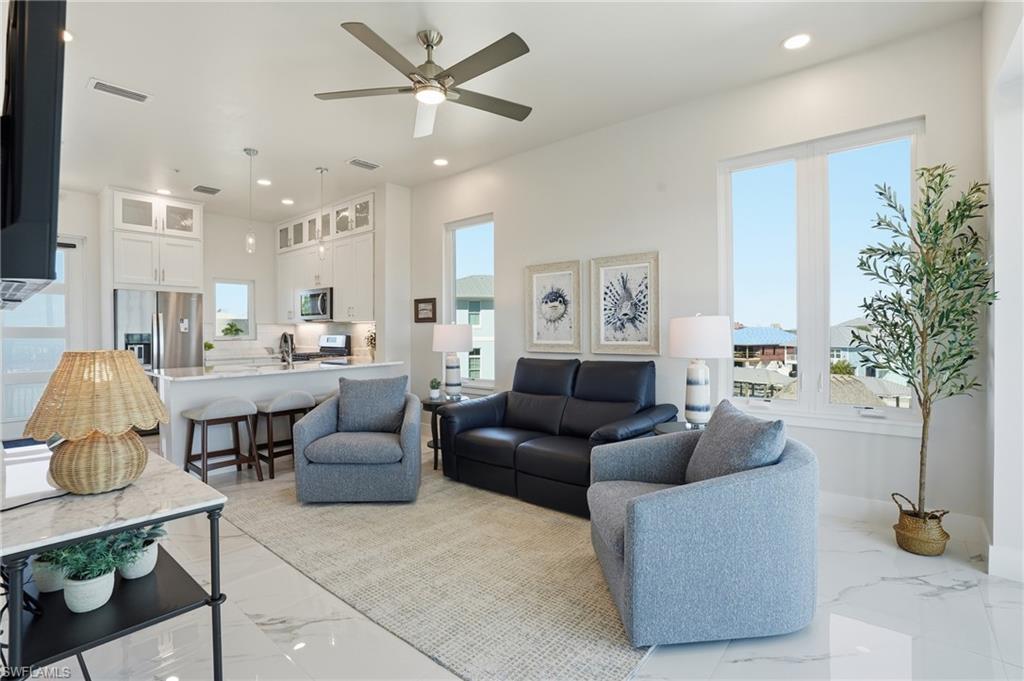 Living room with recessed lighting, ceiling fan, and light marble finish floors - Virtually Edited Image