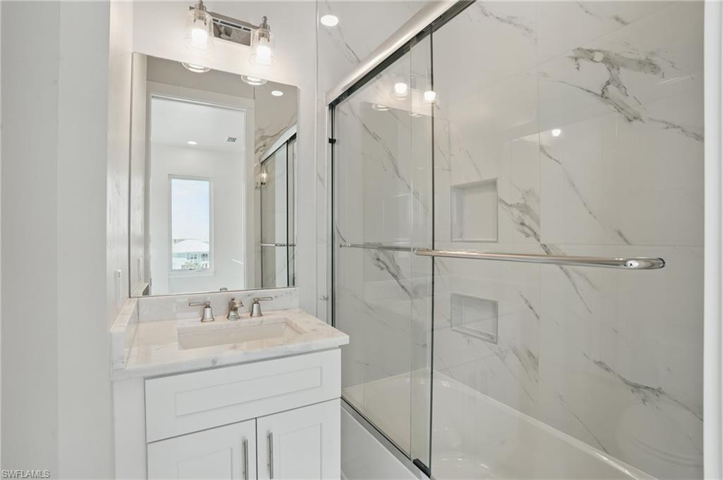 Guest bath featuring combined bath / shower with glass door and vanity - VIRTUALLY EDITED