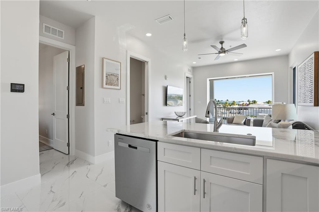Kitchen featuring open floor plan,  - Virtually Edited Imagestainless steel dishwasher, light stone countertops, white cabinets, and ceiling fan
