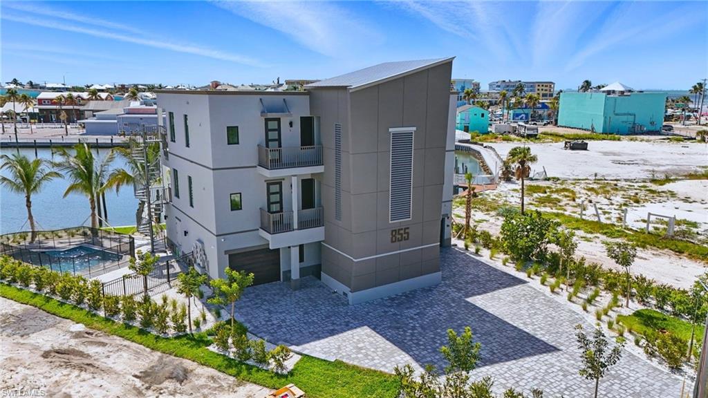 Modern multi-story property featuring a flat roofline and a two-car garage - Virtually Edited Image
