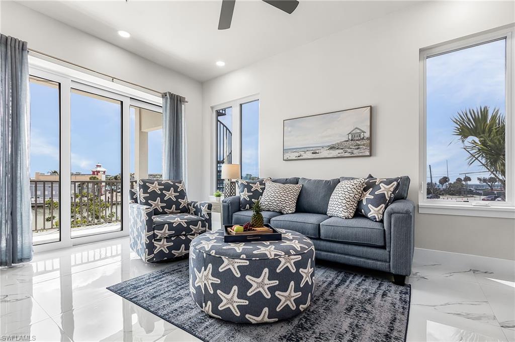 Spacious living area featuring polished tile flooring, abundant natural light from large windows, and direct access to an outdoor balcony - Virtually Edited Image