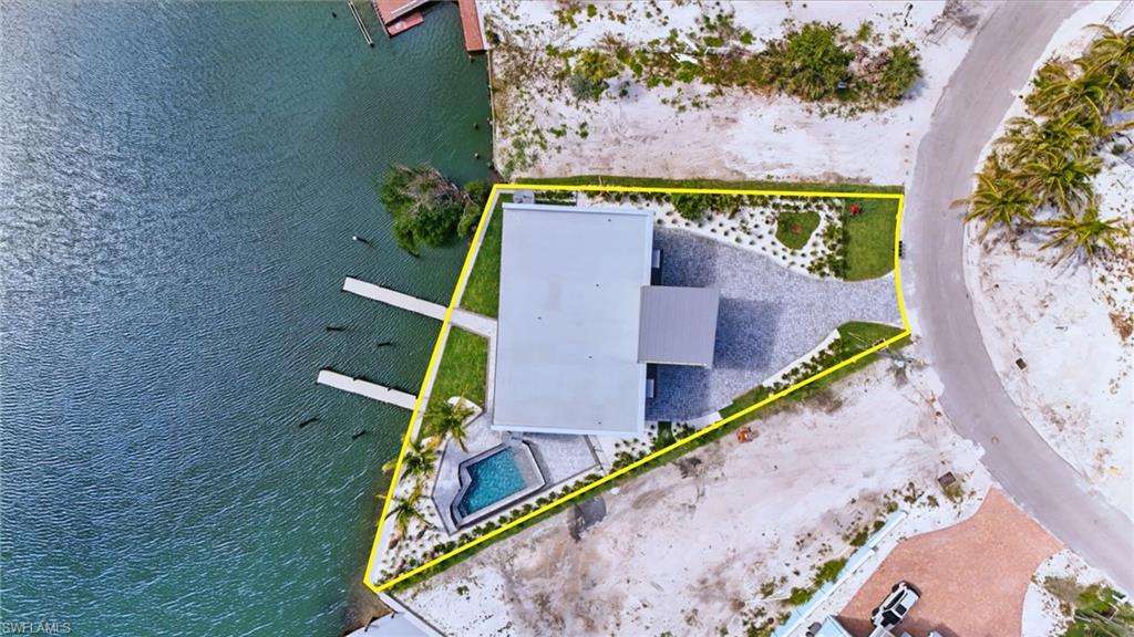 Waterfront property featuring a contemporary flat-roof residence - Virtually Edited Image
