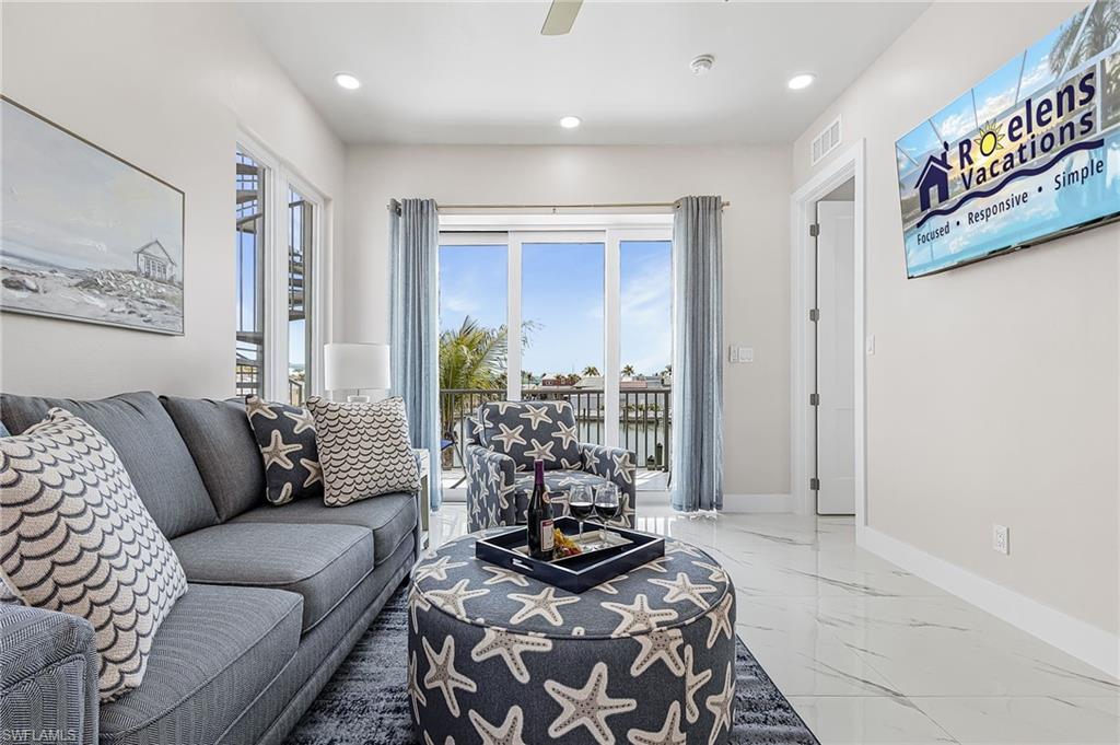 Bright living area featuring large sliding glass doors, recessed lighting, and tile flooring - Virtually Edited Image