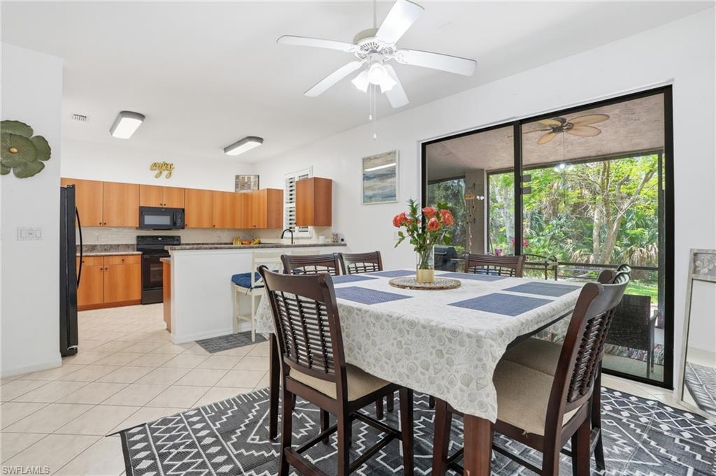 Dining area featuring tile flooring, a ceiling fan, and sliding glass doors to the exterior lanai