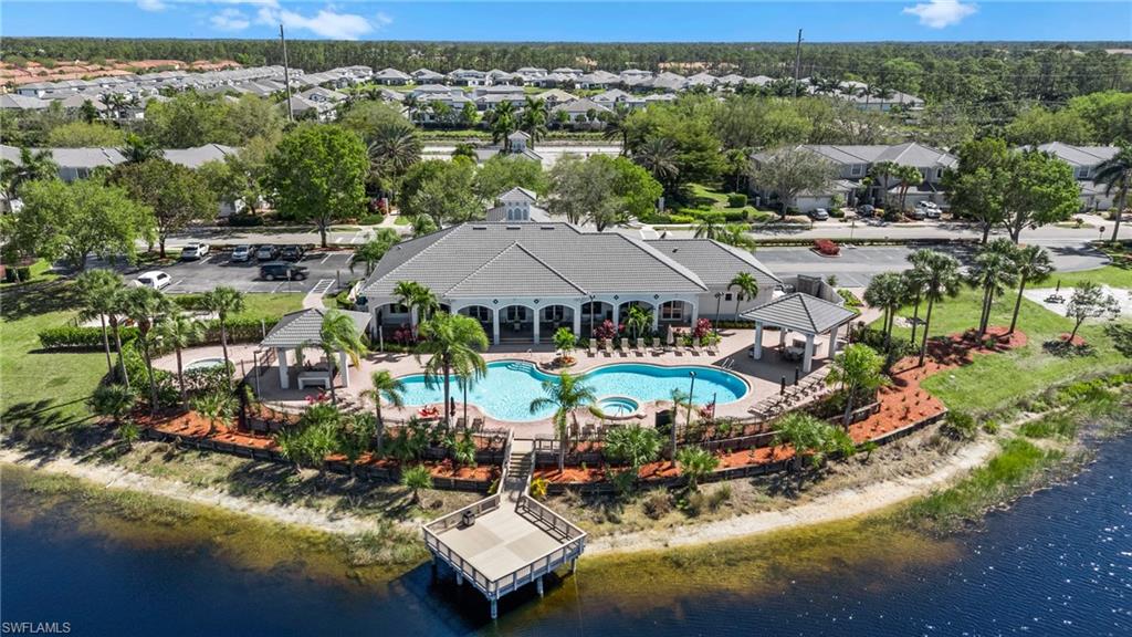 Resort-style pool area featuring a large freeform swimming pool, integrated spa, and spacious paver deck