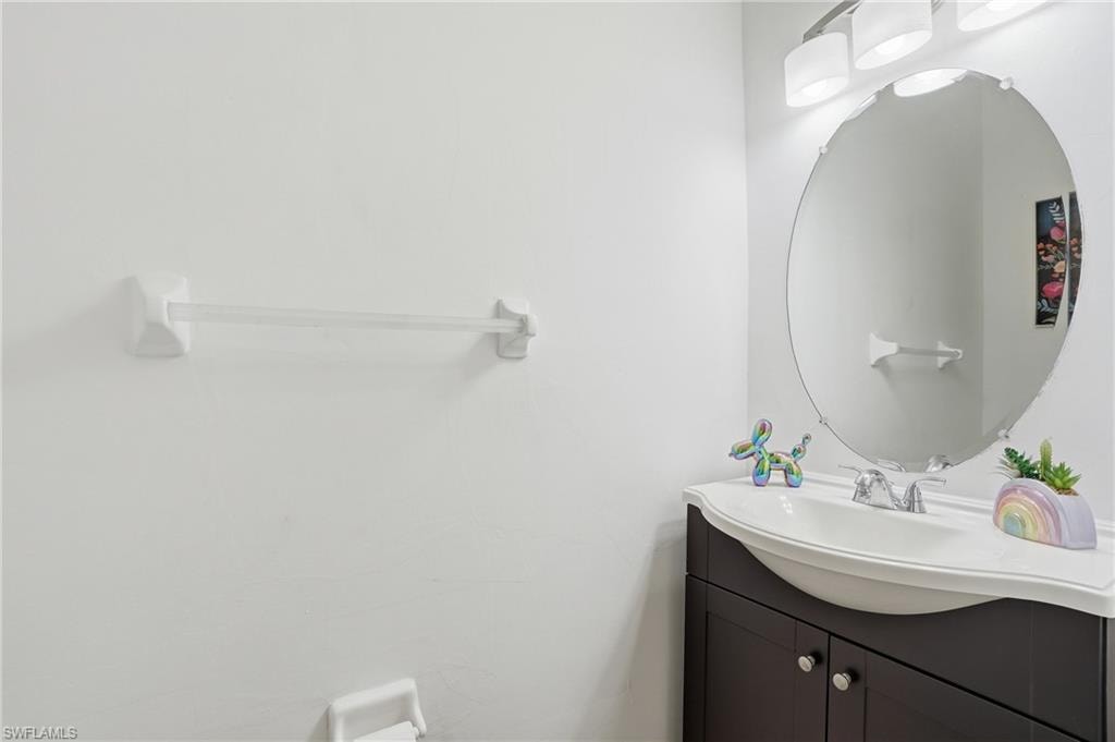 Modern vanity with a dark wood-finish cabinet and an integrated white sink