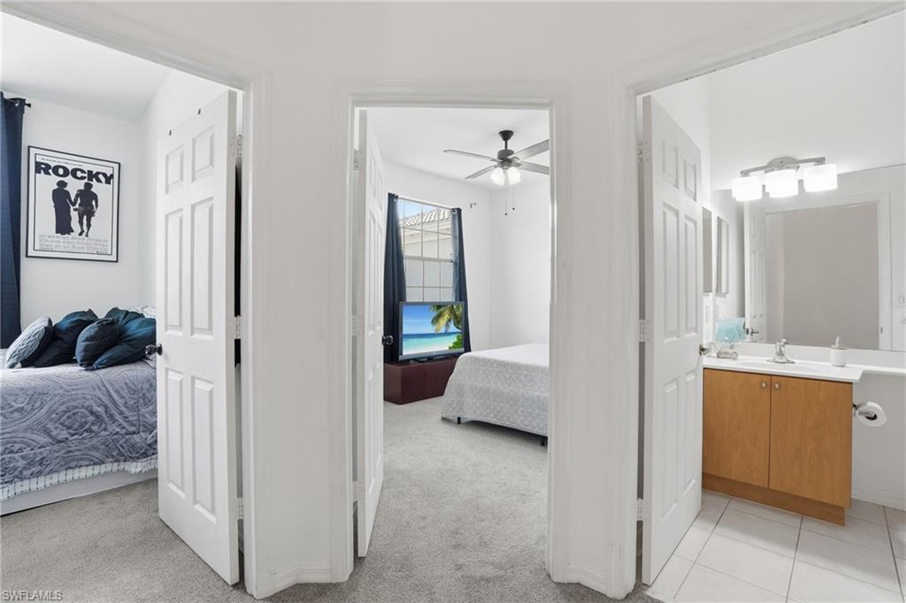 White paneled doors opening to carpeted rooms and a tiled bathroom