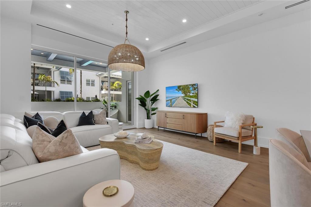 Living room with recessed lighting, wood finished floors, wood ceiling, and baseboards