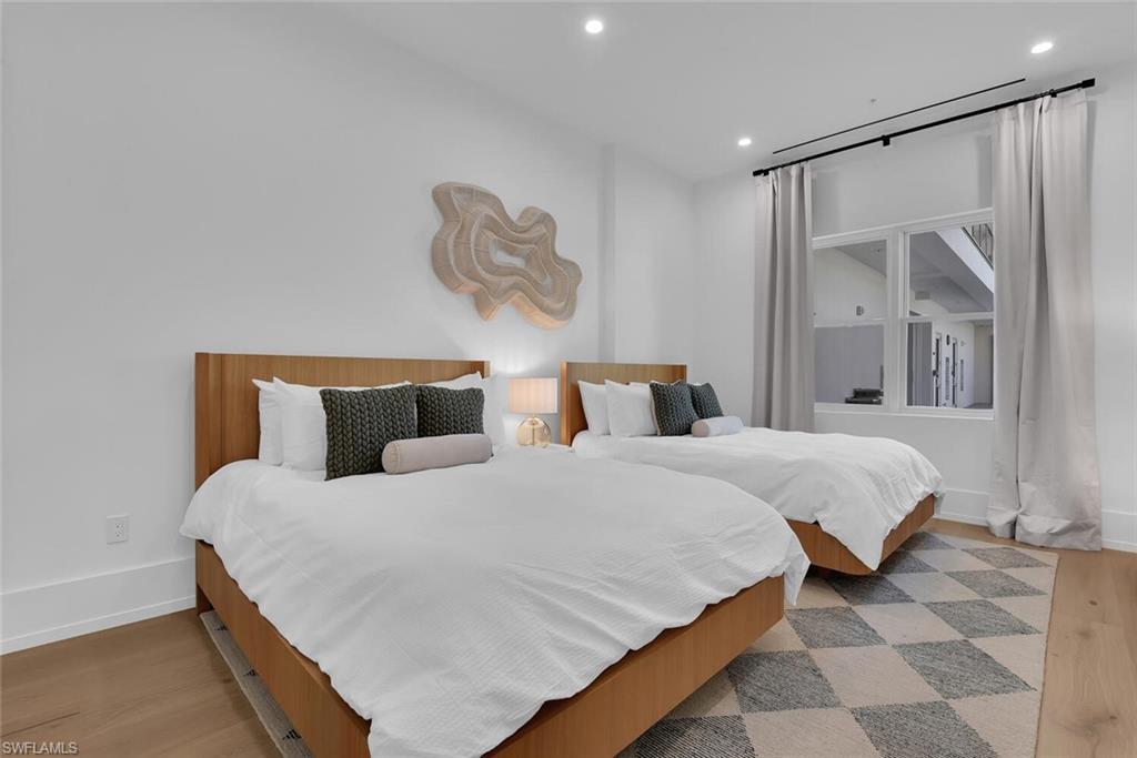 Bedroom with wood finished floors, recessed lighting, and baseboards