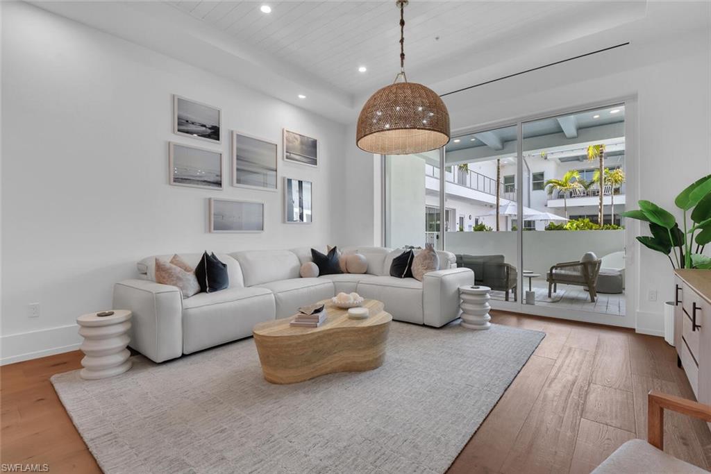 Living room with wood finished floors, recessed lighting, baseboards, and wood ceiling