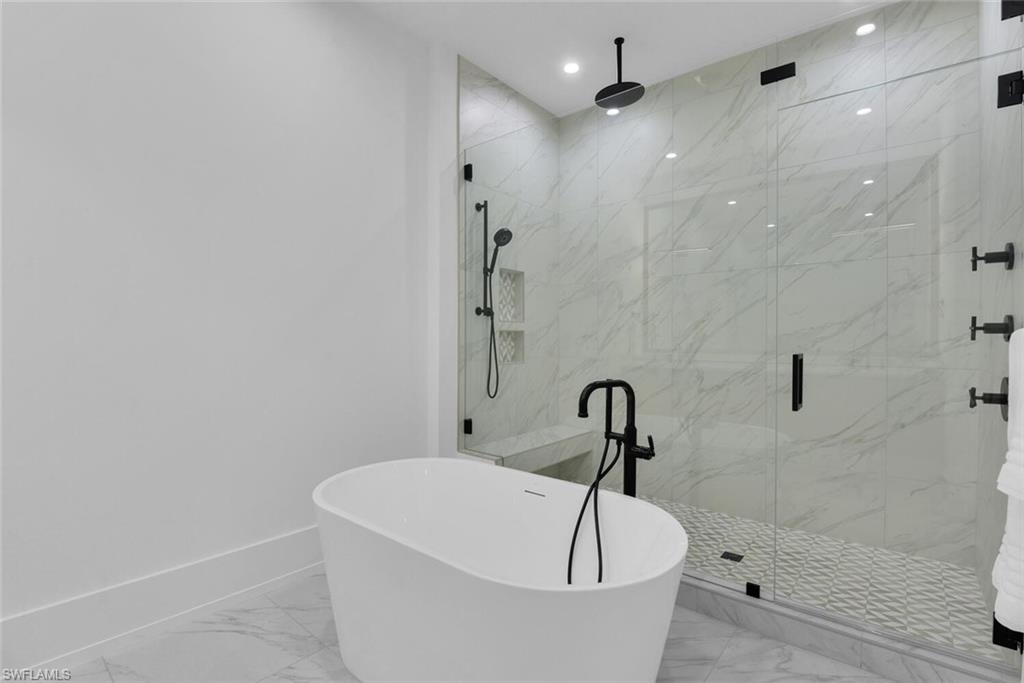 Full bathroom with marble finish flooring, a marble finish shower, a freestanding tub, baseboards, and recessed lighting