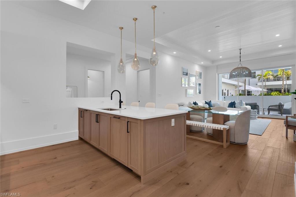 Kitchen with a sink, light wood-style flooring, open floor plan, plenty of natural light, and recessed lighting