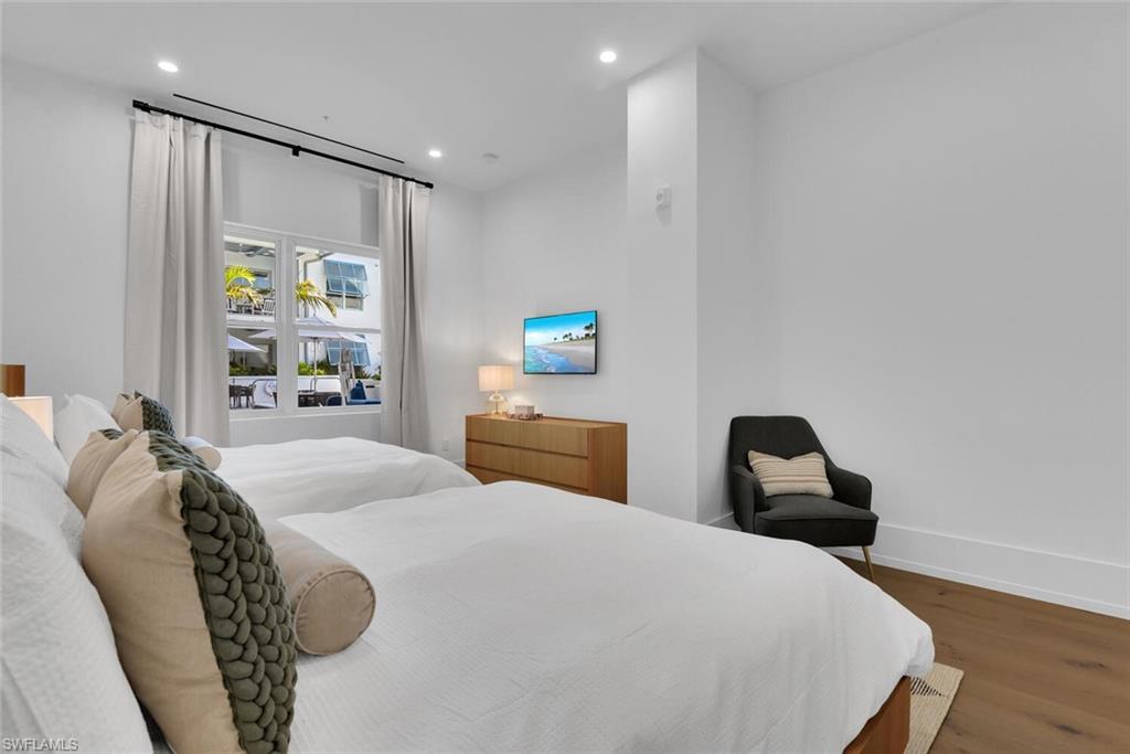 Bedroom featuring wood finished floors, recessed lighting, and baseboards