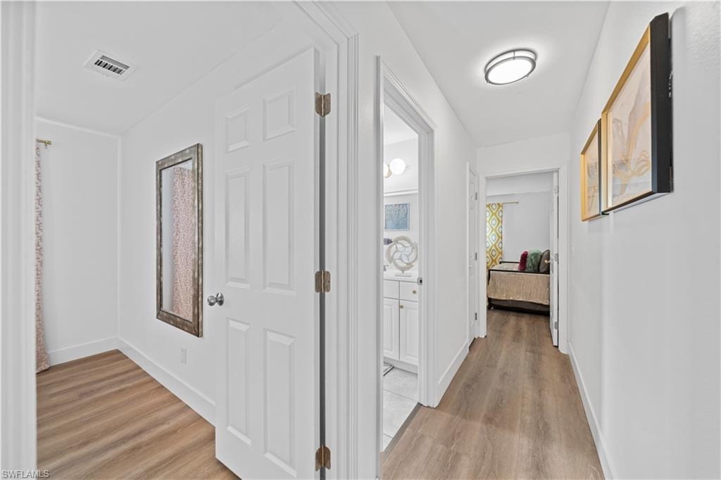 Corridor featuring wood-finish flooring, recessed lighting, and white paneled doors