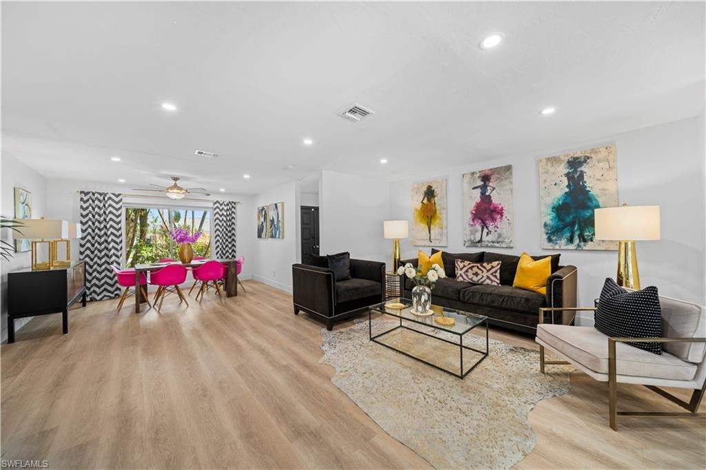 Open-concept living and dining area featuring light wood-finish flooring, recessed lighting, and a ceiling fan
