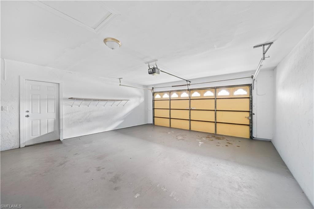 Spacious garage with a light-colored concrete floor and textured white walls