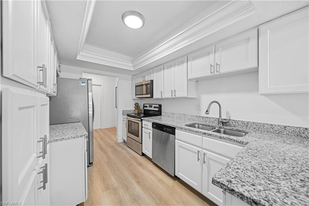 Kitchen featuring white shaker-style cabinetry, granite-finish countertops, and stainless steel appliances