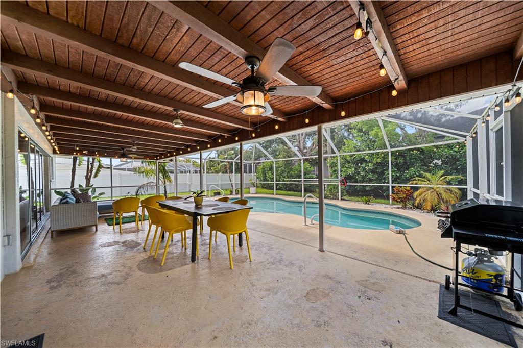 Screened pool patio featuring a wood-plank ceiling, exposed beams, and multiple ceiling fans