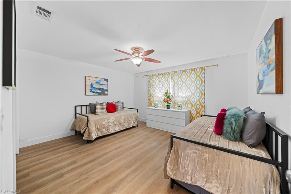 Spacious room featuring wood-finish flooring and a ceiling fan