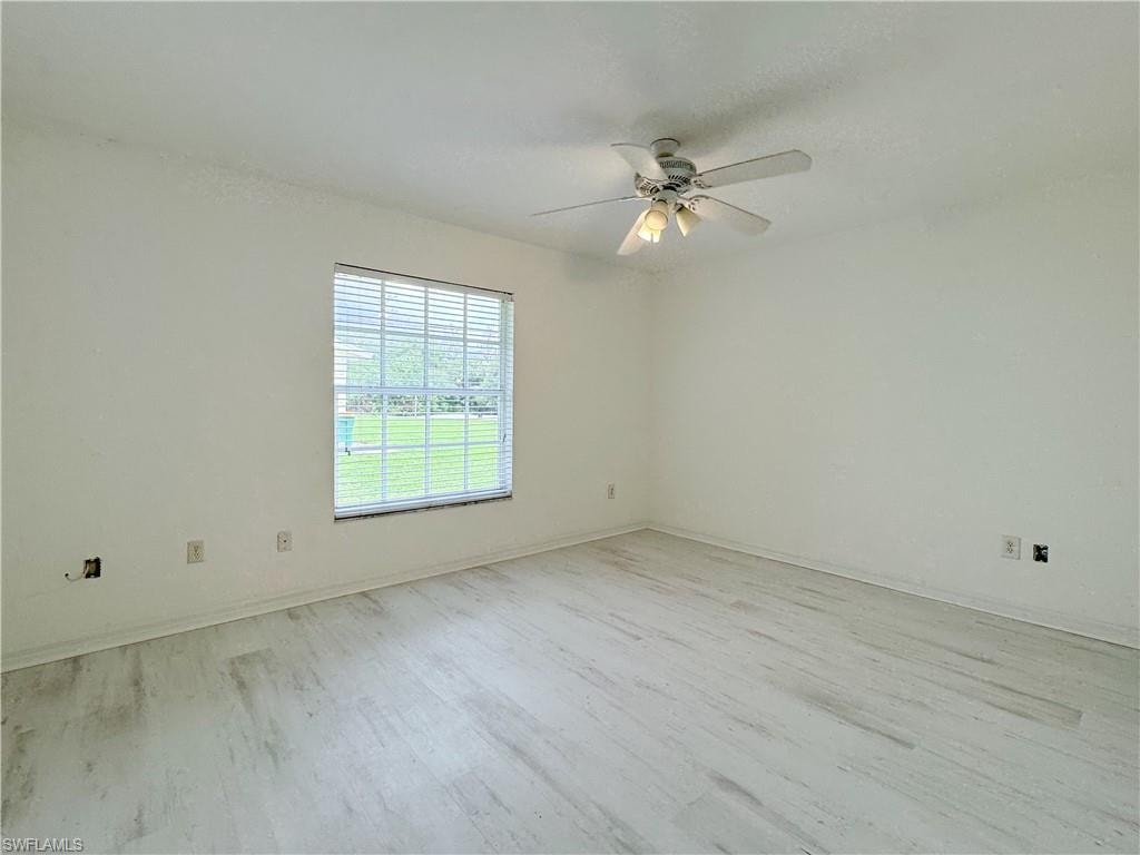 Unfurnished room with ceiling fan and light wood-type flooring