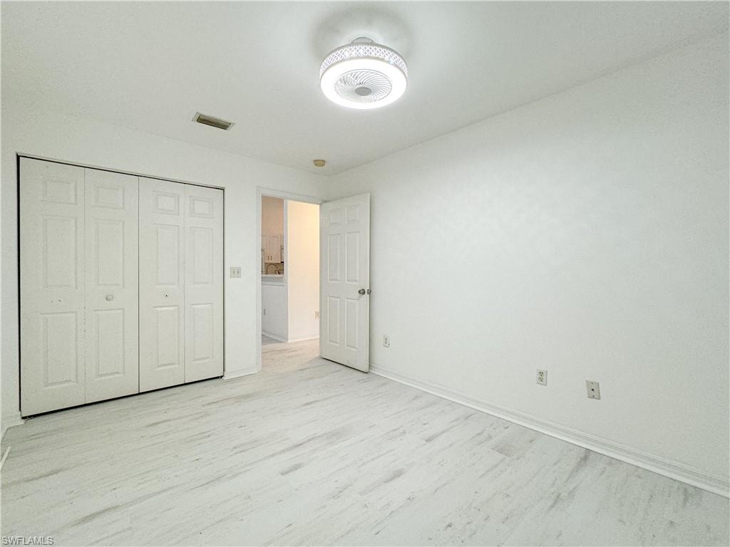 Unfurnished bedroom featuring light wood-type flooring and a closet